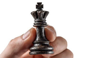 Hand holding a black king chess piece isolated on transparent background