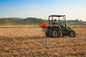 Fototapeta premium Tractor seeding crops in the field during spring planting season on farm