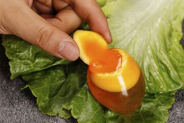 Golden Soft-Boiled Egg with Runny Yolk on Fresh Lettuce Leaves - Perfect Coagulation Technique