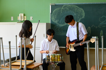 文化祭に向けてバンド練習をする生徒たち　学校の教室での青春イメージ