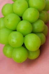 Fresh Shine Muscat or Vitis grapes close up, isolated on pink background.
