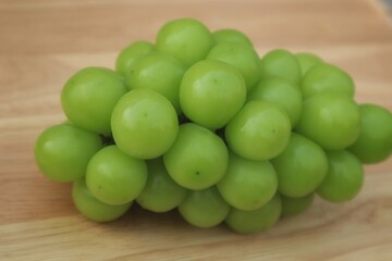 Fresh Shine Muscat or Vitis grapes close up, isolated on wooden backgroun