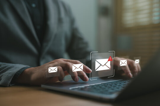 Businessman checking email notifications on laptop with alert icon, representing digital communication, work messages, productivity and online correspondence in the workplace.