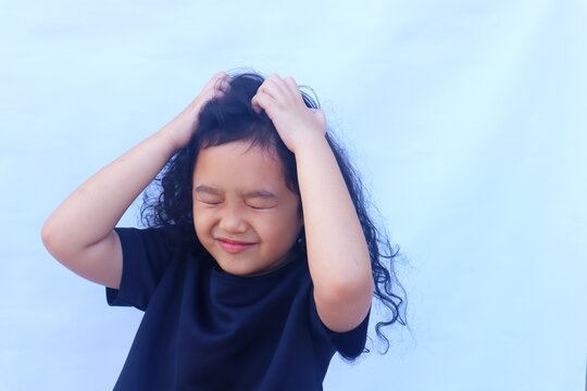 Asian girl scratching head, because scalp is itchy or there are head lice, isolated on white background.
