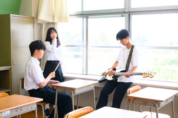 文化祭に向けてバンド練習をする生徒たち　学校の教室での青春イメージ