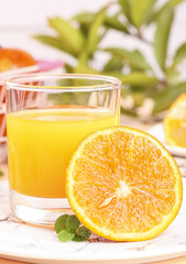 Fresh Orange Juice with Sliced Citrus Fruit and Mint on White Wooden Table