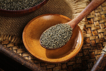 Organic Millet Grains in Wooden Spoon - Healthy Ancient Grain Superfood on Rustic Woven Background