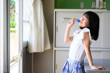 教室でラムネを飲む小学生の女の子　学校生活