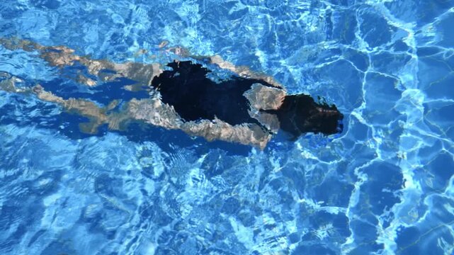 girl enjoying a refreshing swim underwater in a vibrant blue pool, surrounded by the serene ambiance of summer, creating an idyllic scene full of relaxation and leisure