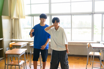 学校の教室でダンスの練習をする男子生徒　青春・学校生活のイメージ