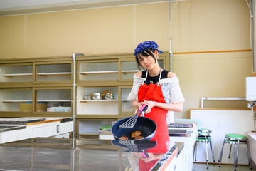  料理教室で調理を学ぶ小学生の女の子と料理の先生　教育と食育イメージ