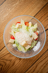 A colorful salad featuring lettuce, tomatoes, and cheese, beautifully arranged in a glass bowl