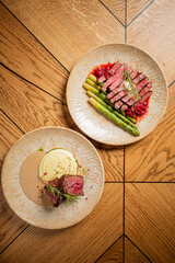 A beautifully arranged plate showcases tender steak with asparagus and velvety mashed potatoes