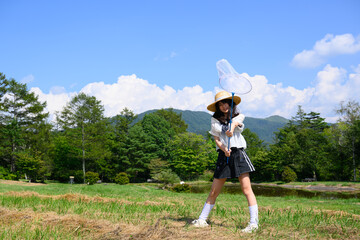 青空の下で虫取りを楽しむ女の子