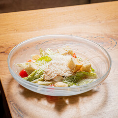 Vibrant Caesar salad with greens, croutons, and cheese arranged on a table