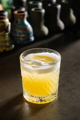A golden drink with lemon slices rests elegantly on a rustic table, glowing softly
