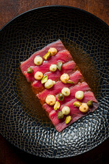Culinary art showcases a stunning tuna tartare, enhanced with vibrant sauces and herbs