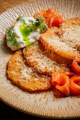 Crispy plantains are served with creamy sauce, smoked salmon, and fresh herbs for a flavorful meal