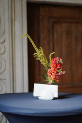 Minimal floral centerpiece with napkins on a cocktail table in a historic venue