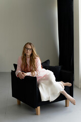 Young blondie attractive woman in eye glasses siting in studio. Business smart woman concept