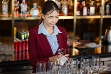 Asia woman cleaning a glass at bar	