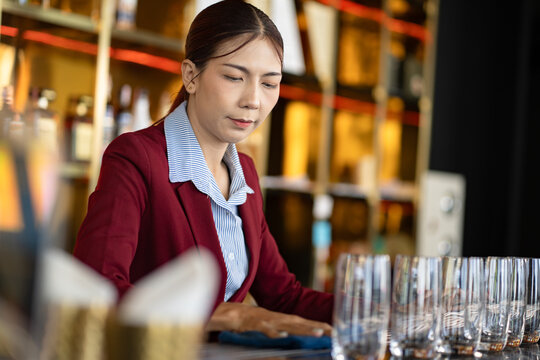 Asia woman cleaning a glass at bar	