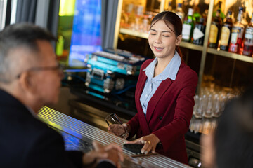 Attractive saleswoman, cashier serving customers at a retail store counter or bar restaurant counter.	
