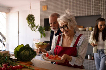 Grandparents preparing food together in a bright home kitchen