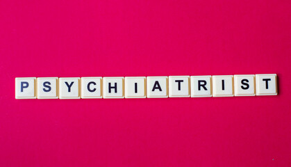 Psychiatrist word with alphabet cubes isolated on red background
