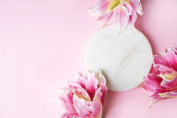 Marble round platform with pink lily flowers on pastel background