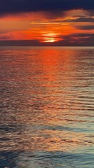 Obraz premium Sunset sky reflecting in the Baltic sea, view from the sandy shore in Sweden.