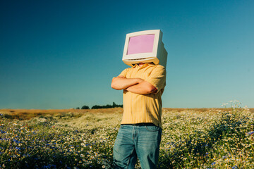 AI person with vintage CRT monitor head standing on summer meadow