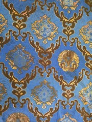 Close-up of traditional Indonesian batik fabric with blue and golden ornamental motifs