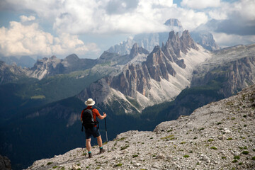 Fototapeta premium Man traveler traveling alone in breathtaking landscape of Dolomites Mounatains. Travel lifestyle wanderlust adventure concept.
