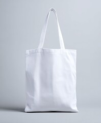 A simple white tote bag, clean and minimal on a gray background, ready for design