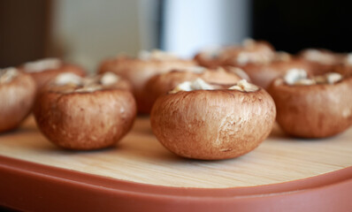 bunch of fresh raw mushrooms on a rustic wooden cutting board, natural light