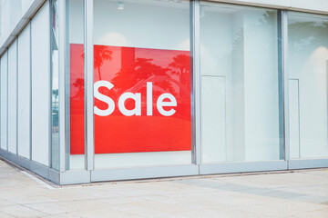 Sale signs in store window during seasonal discount