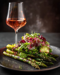 Crisp grilled asparagus and fresh salad paired with rosé wine for an elegant dining scene.