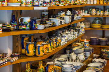 Fototapeta premium Typical souvenirs in a shop in historic village San Gimignano, Tuscany, Italy. Detail of a local shop in the streets. Traditional souvenirs of ceramics. Europe tourism or vacation travel concept.