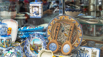 A vibrant display of Portuguese souvenirs featuring traditional ceramic plates, cork trivets, and illustrated tiles, reflecting the rich cultural heritage and artisan crafts of Porto.