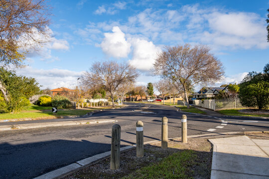 A suburban chicane or curbed road narrowing with traffic calming bollards for pedestrian safety, in a residential neighborhood of Melbourne, Australia. Concept of road safety, urban planning