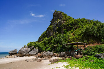 Happy Bar, Thung Yang Beach, Chumphon Province. The boat is moored on a beautiful beach in Thailand and has a blue and white flag.