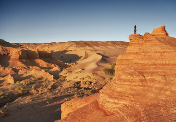 A Solitary Explorer Roaming in a Stunning Desert Landscape During Sunrise