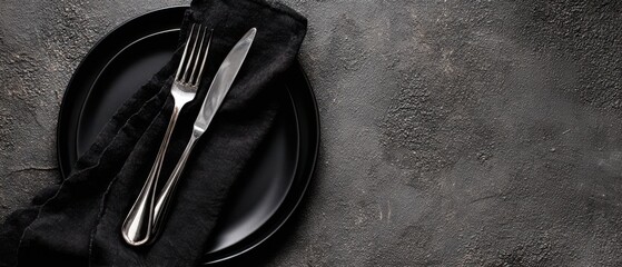 The Black Plate and Silver Cutlery on Dark Rustic Textured Tabletop