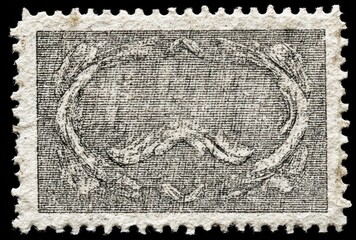 Obraz premium An old, blank, grayscale postage stamp with a textured surface and decorative border, set against a black background
