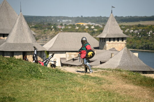 Fototapeta knights in uniform fight with swords against the backdrop of a fortress
