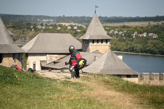 Fototapeta knights in uniform fight with swords against the backdrop of a fortress