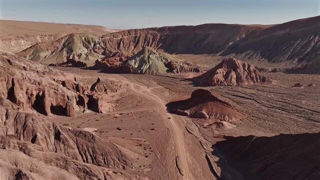 Aerial view of the arid landscape and geological formations with contrasting colors in Valle del Arcoiris, San Pedro de Atacama, Chile.