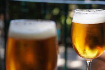 Two glasses of refreshing golden beer with frothy heads.