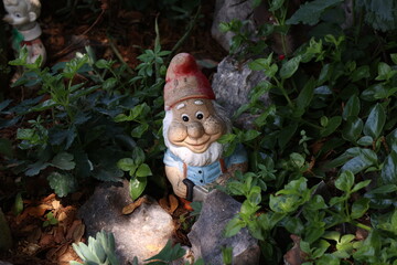 Decorative gnome among plants in the garden